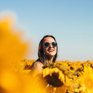 woman in black sunglasses on yellow flower field during daytime