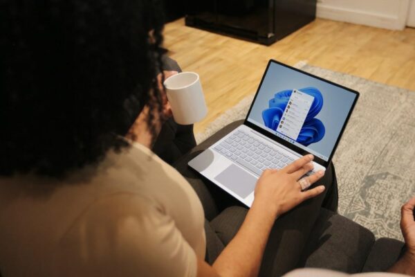 Female on her Microsoft laptop at work drinking coffee