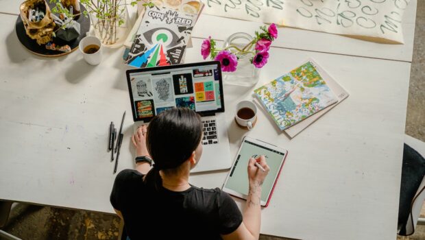 Free Photo of Woman Writing on Tablet Computer While Using Laptop Stock Photo