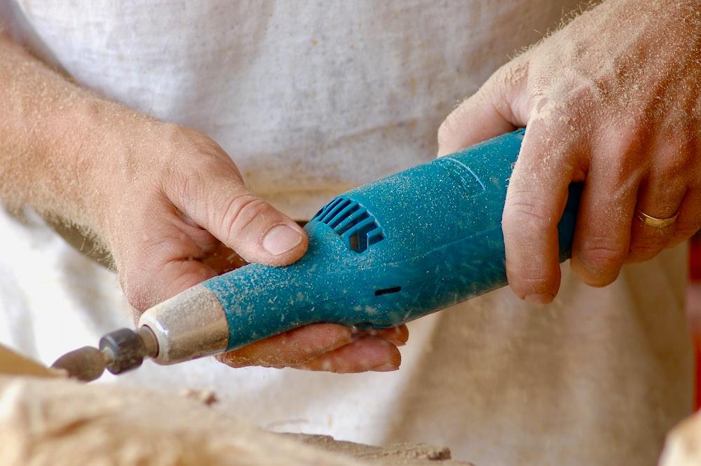 person holding blue power tool